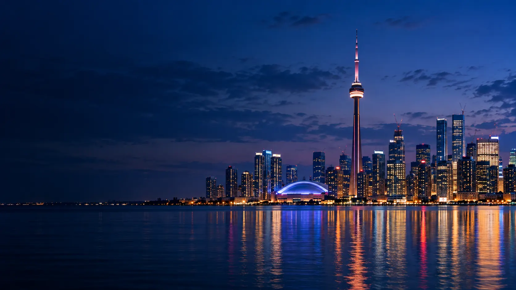 Toronto skyline at dusk across Lake Ontario